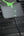Phone case with green accents attached to a car vent, charging cable visible.