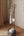 Black metal coat rack with clothes in a room with a curtain and wall art.