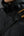 Black jacket with a visible Terrex logo on a gray background