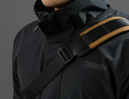 Black jacket with a visible Terrex logo on a gray background