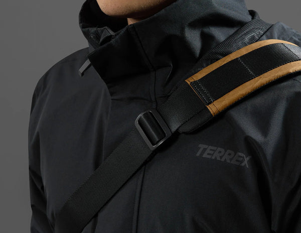 Black jacket with a visible Terrex logo on a gray background