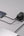 Two electronic devices connected to a power adapter on a gray surface