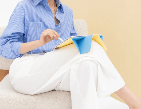 Person sitting on a couch holding a tablet with Moft Dynamic Folio Case for iPad Pro 13-inch (M4).