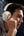 Person wearing white headphones with a dark background