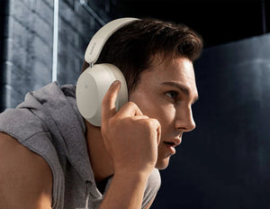 Person wearing white headphones with a dark background