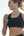 Woman in athletic wear running outdoors with a clear sky background