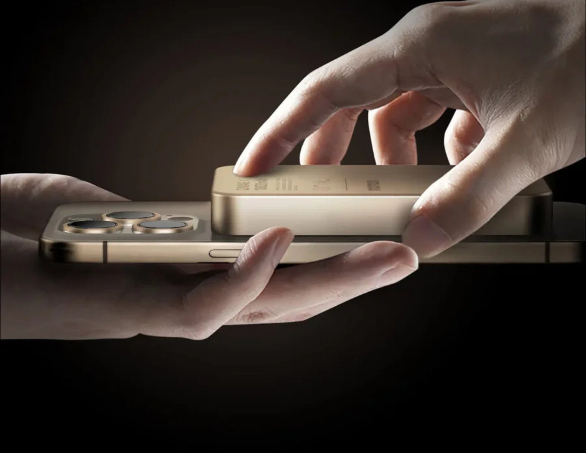 Two hands holding a gold smartphone with a dark background