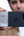 Person holding a smartphone with a Lexar card reader attached, blurred background