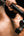 Person using a Kica Evo Fascia Massage Gun on their back against a dark background