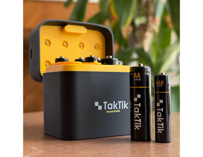 TakTik battery charger with batteries on a wooden surface