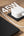 White power adapter with cable on a wooden surface next to a laptop, with '45W' text above.