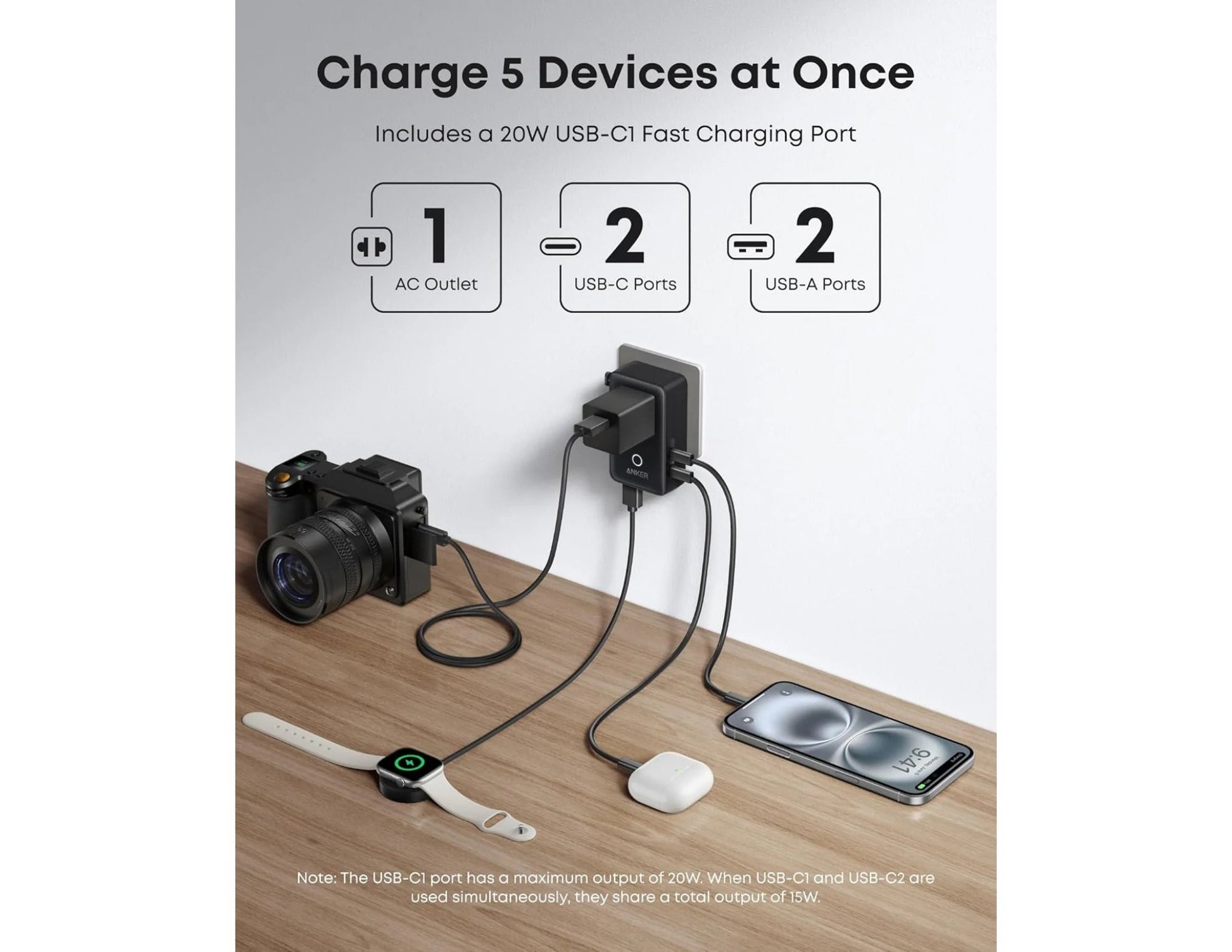 Anker Nano 5-in-1 20W Travel Adapter A9215311 with multiple devices plugged in, including a camera, smartwatch, and phone, on a wooden surface.