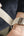 Person adjusting a beige fabric strap on a wrist.