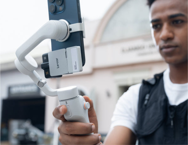 Person holding a smartphone gimbal with a blurred background