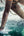 Person water skiing with legs and skis visible above water