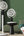 Two white oscillating fans on stands with a remote control in a room setting.