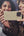 Two women taking a selfie with a phone, with a blurred background