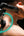 Person using a Kica Evo Fascia Massage Gun on their shoulder with a black background