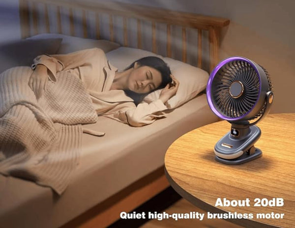 Person sleeping in bed with a small fan on a nightstand, indicating a quiet operation.