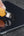 Person using a yellow utility knife to open a black smartphone.
