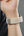 Close-up of a wrist with a beige woven fitness tracker.