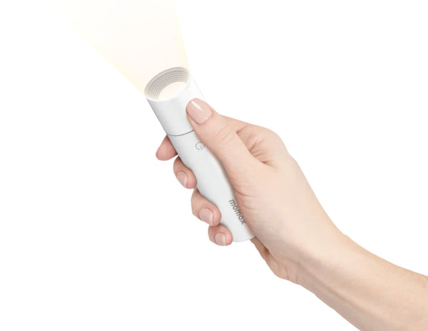 Hand holding a white flashlight with a soft glow on a white background
