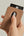 Hand holding a Pitaka MagSafe Woven Wallet – Magsafe Compatible MWW240 with a card inserted on a beige background