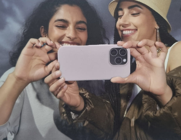 Two women holding a phone together, smiling.