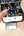 Person holding a smartphone with a video call app open, using a Lexar device on the screen.