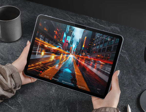 Person holding a tablet displaying a cityscape with neon lights.