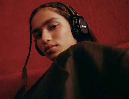 Person wearing headphones against a red background