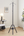 Elegant vertical cloth burner stand black with triangular base on a wooden floor.