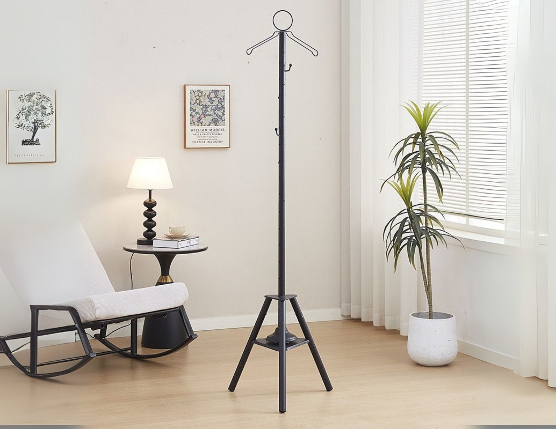 Elegant vertical cloth burner stand black with triangular base on a wooden floor.