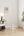 Elegant vertical cloth burner stand white with triangular base on a wooden floor.